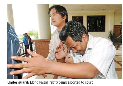 Mohd Faizal being escorted to court