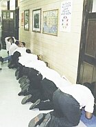 14 boys being punished in a corridor